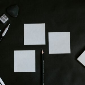 A black table topped with white cards and a pencil